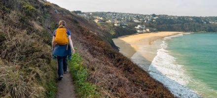 A hiker walks on the South West Coast Path in England. Hillwalk Tours Ltd.