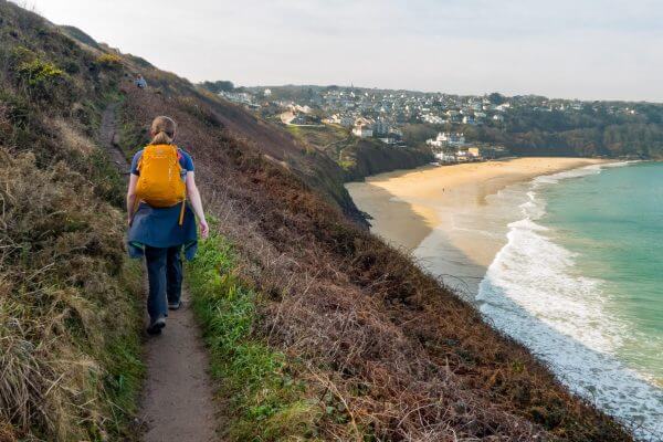 A hiker walks on the South West Coast Path in England. Hillwalk Tours Ltd.